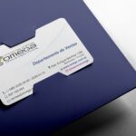 Tarjeta de presentación de Imprenta Omega colocada en una carpeta azul, con diseño corporativo profesional.
