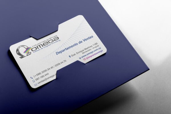 Tarjeta de presentación de Imprenta Omega colocada en una carpeta azul, con diseño corporativo profesional.