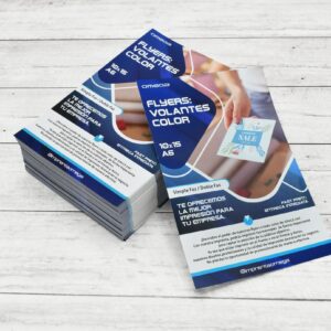 Volantes color tamaño A6 (10x15 cm) impresos por Imprenta Omega, apilados sobre una superficie de madera blanca.