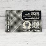 Tarjeta metálica grabada con láser Omega Láser, con diseño geométrico, logo Omega y código QR, sobre fondo de madera clara.