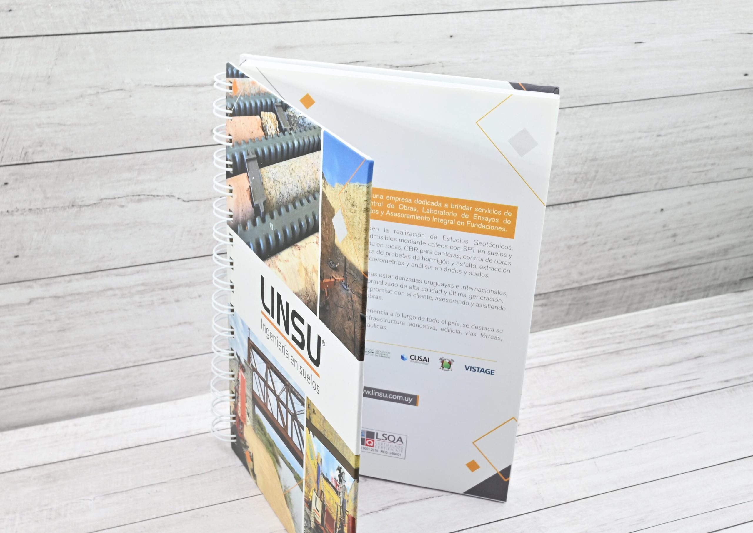 Primer plano de un cuaderno corporativo con encuadernación Wire-O que incorpora un insert impreso personalizado con información institucional.