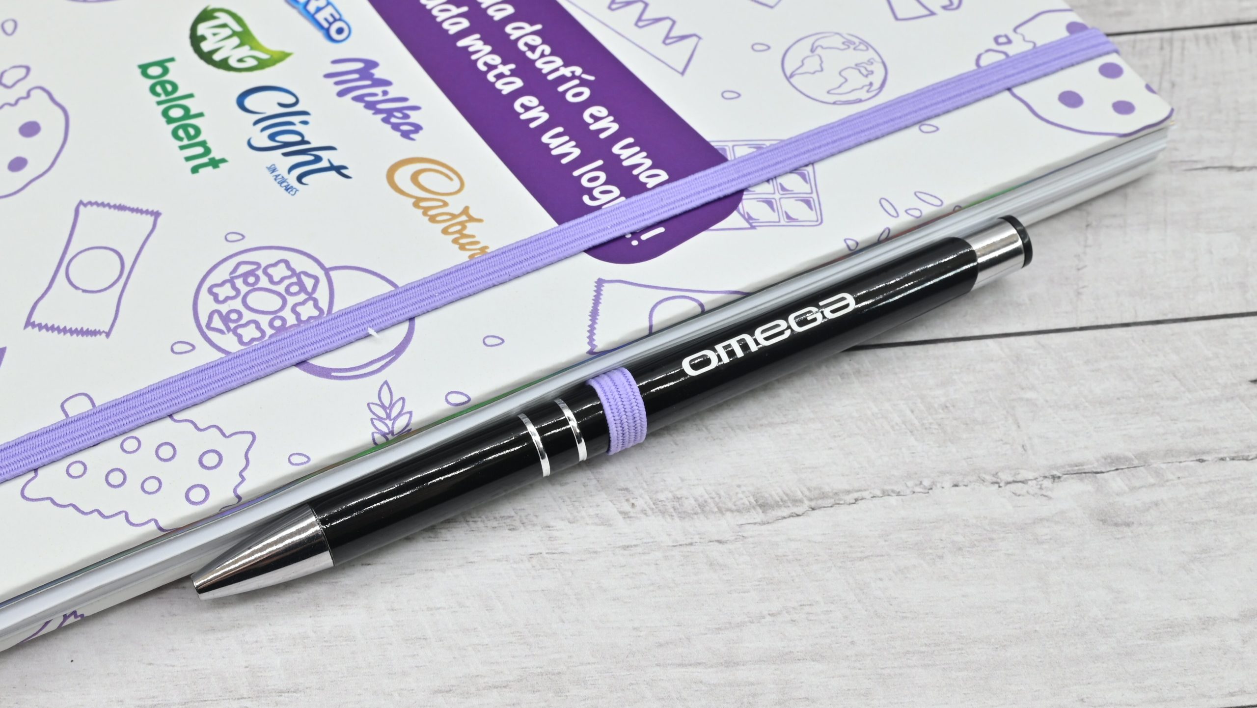 Cuaderno corporativo personalizado con elástico portalapicera y bolígrafo institucional.