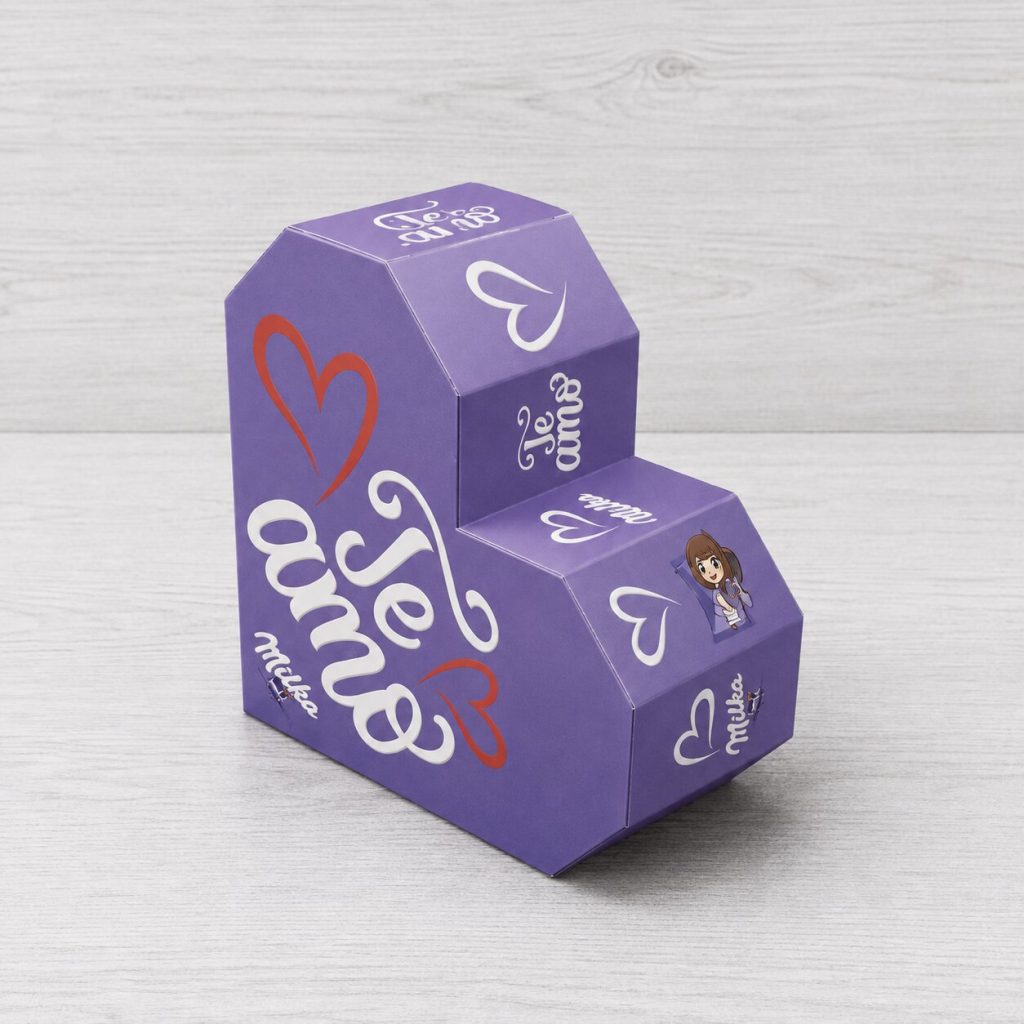 Estuche packaging personalizado Milka con estructura escalonada tipo exhibidor, diseño violeta con corazones y gráfica temática de regalo.