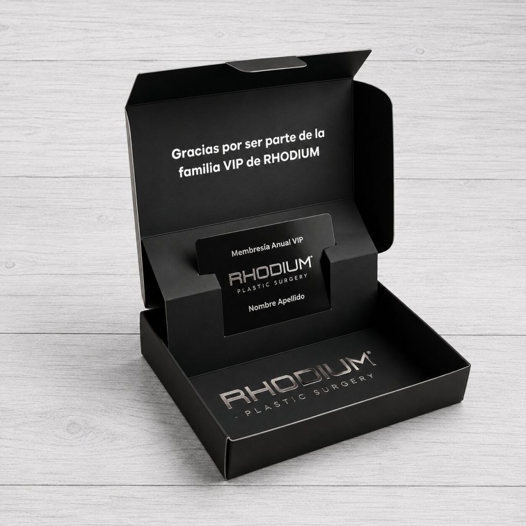 Packaging premium negro Rhodium Plastic Surgery con caja autoarmable abierta, soporte interior para tarjeta VIP y detalles en stamping metálico.